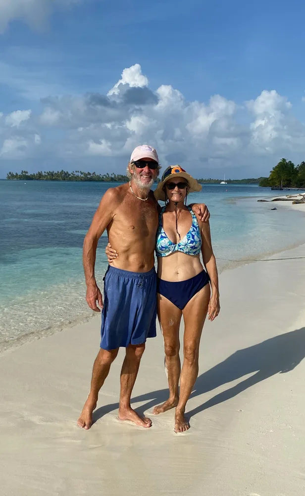 Justin and Sue standing together on a tropical beach